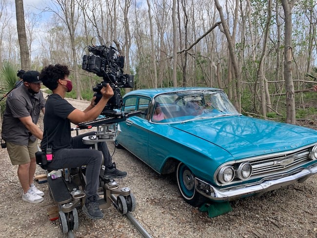crew on set filming car with camera